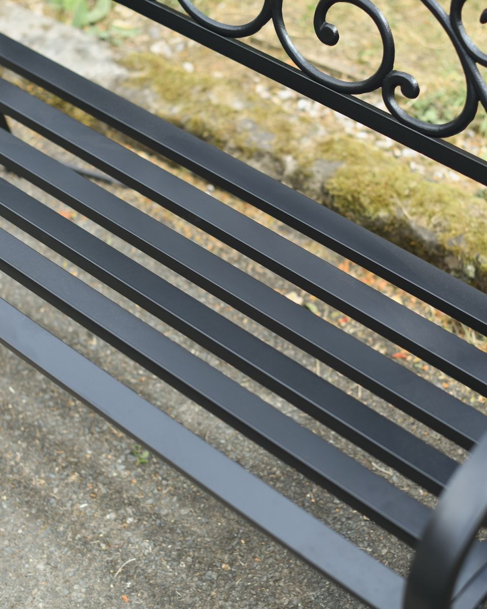 Close up of intricate seat detail on black cast iron outdoor bench Close up of intricate seat detail on black cast iron outdoor bench