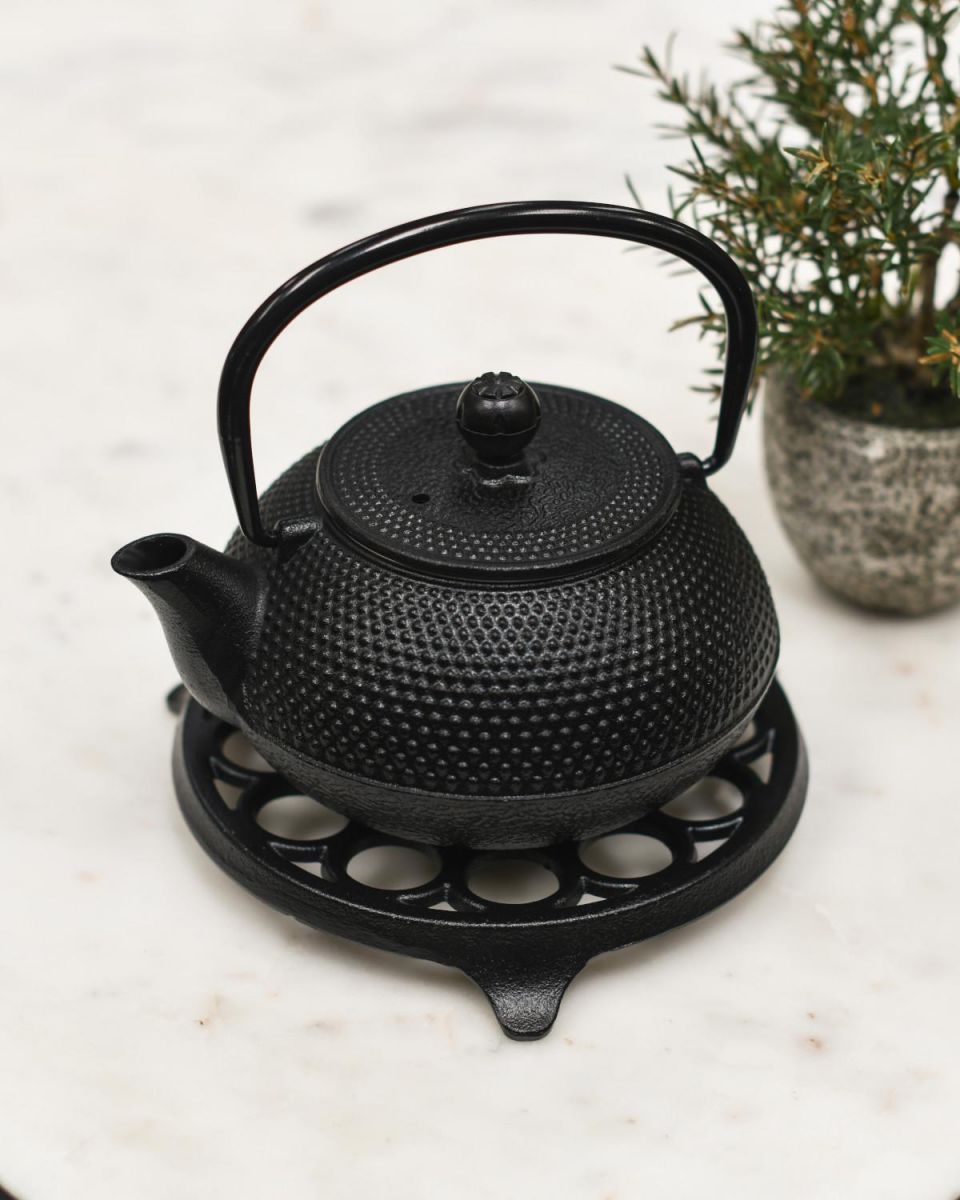 Example of Circular "Spotted" Cast Iron Trivet in Black in Use Example of Circular "Spotted" Cast Iron Trivet in Black in Use