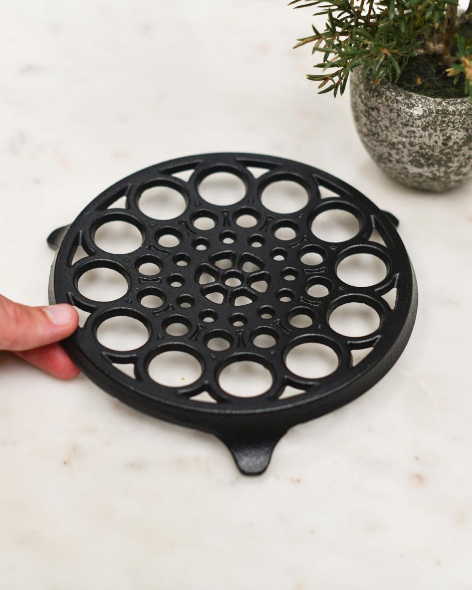 Scale Shot of Circular "Spotted" Cast Iron Trivet in Black Scale Shot of Circular "Spotted" Cast Iron Trivet in Black