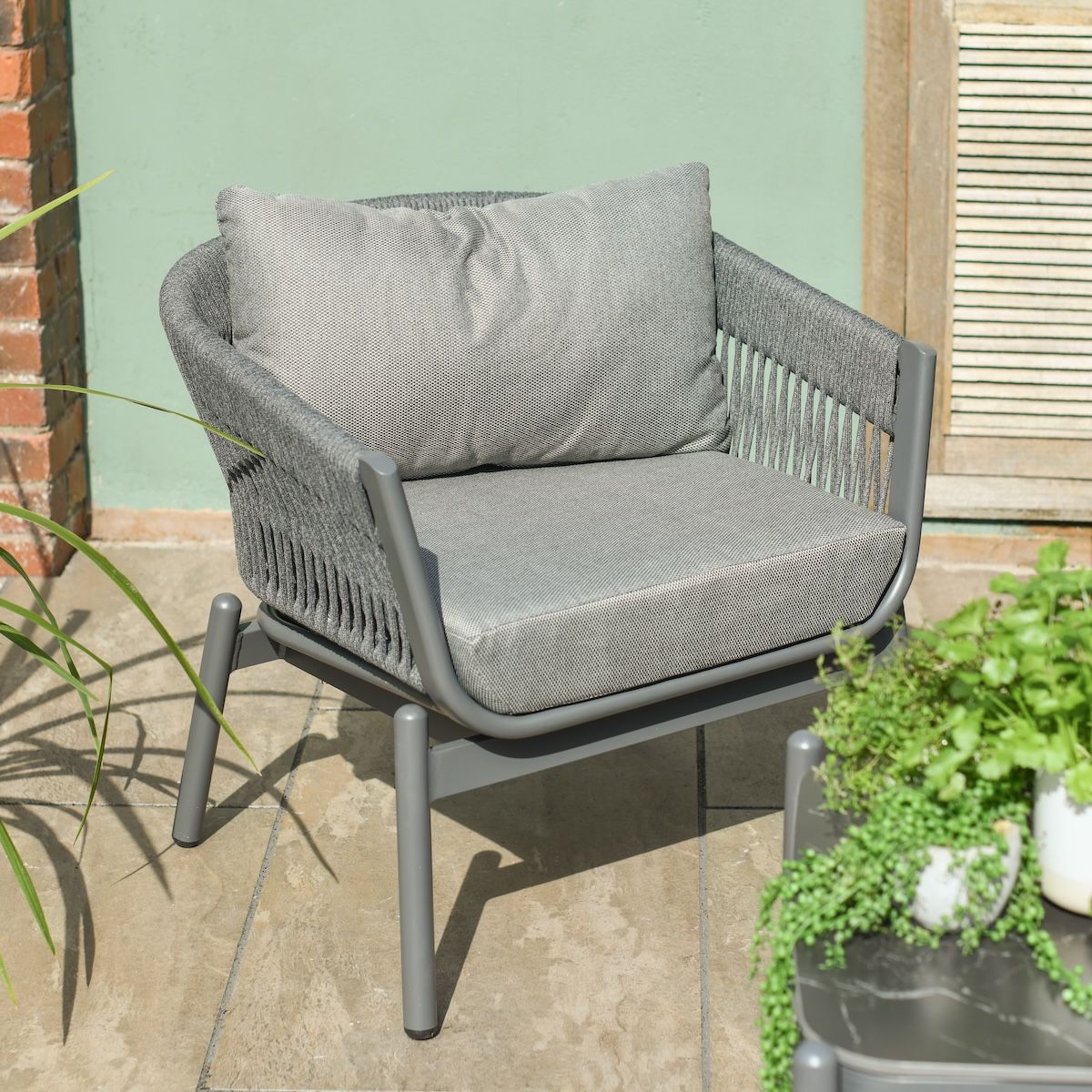 Close up of individual arm chair on modern grey luxury garden furniture set