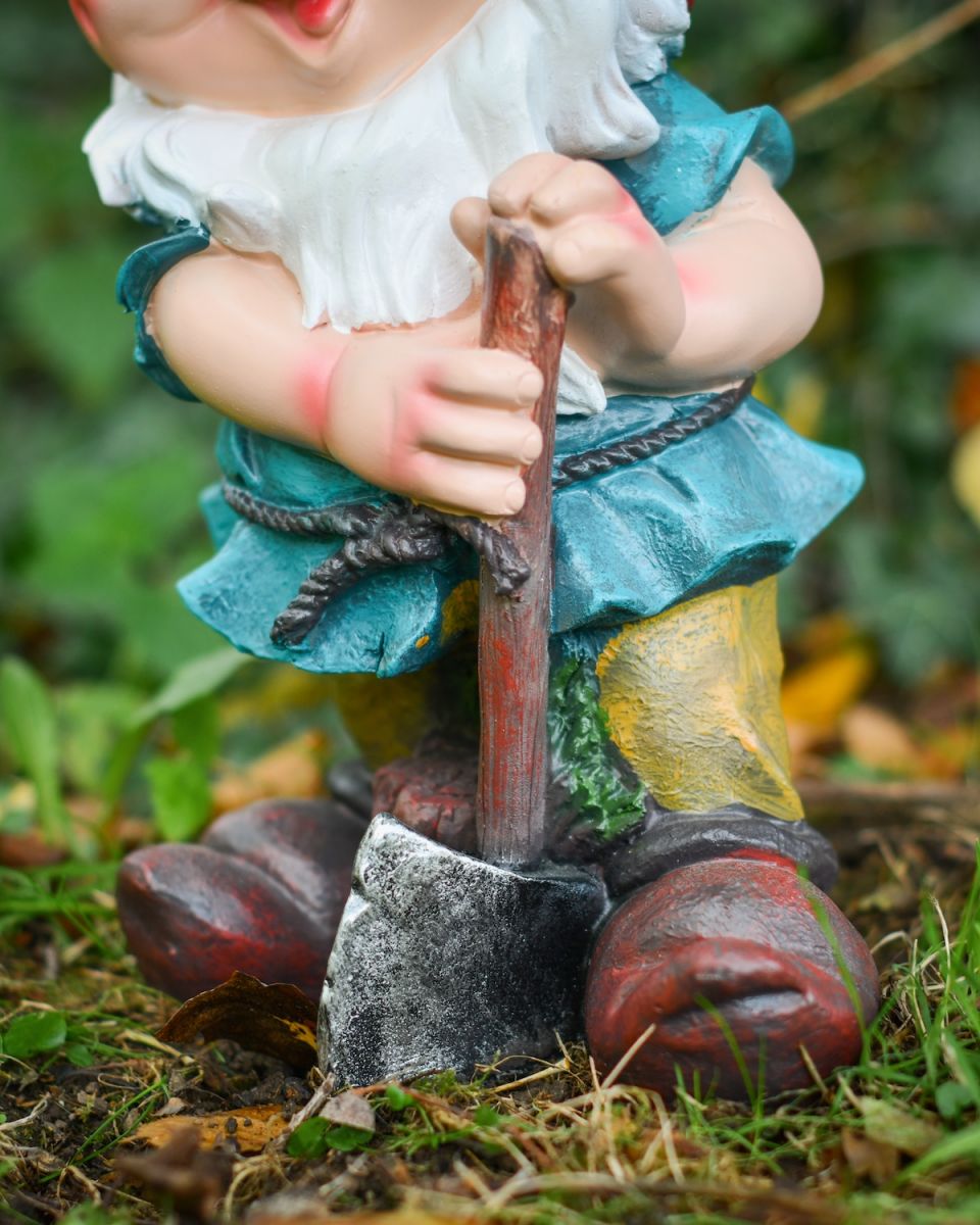 Close up of intricate axe detail on colourful garden gnome sculpture