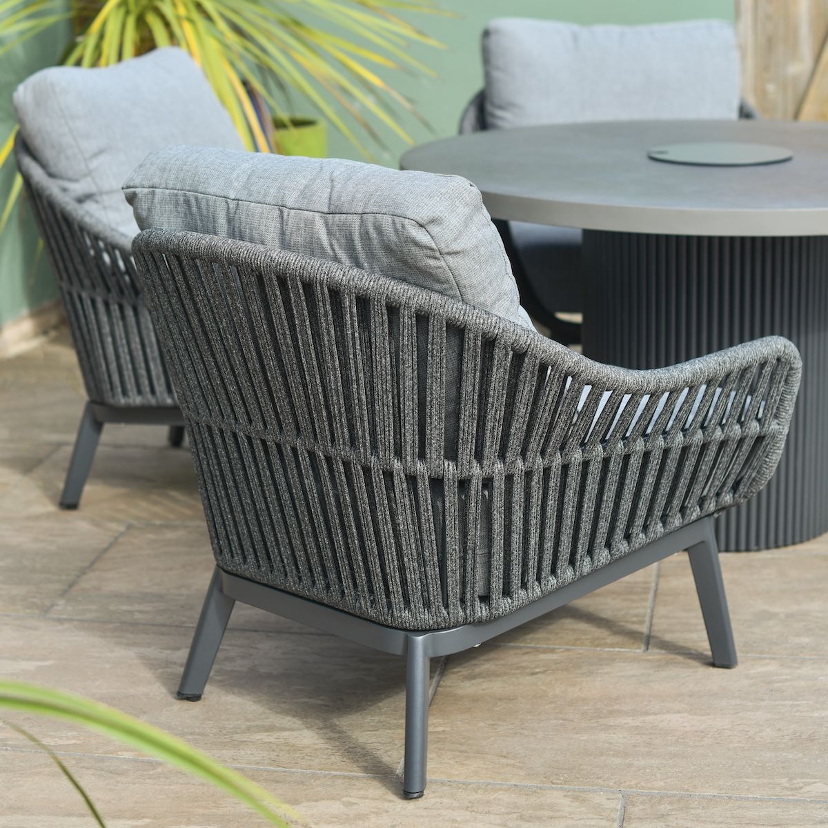 Close up of back of armchair with rope weave detail on four seater patio table and chairs set