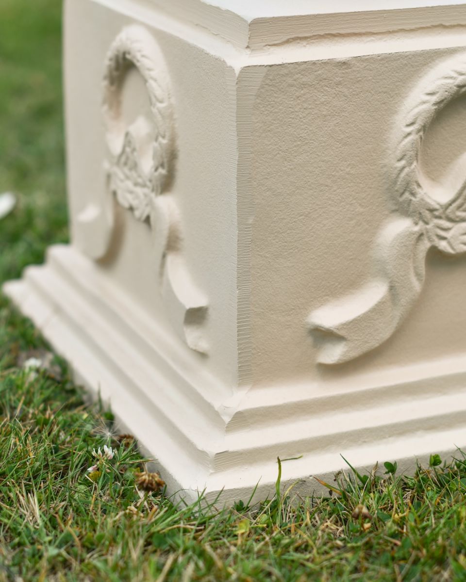 close up of ornate base detail on garden sundial column