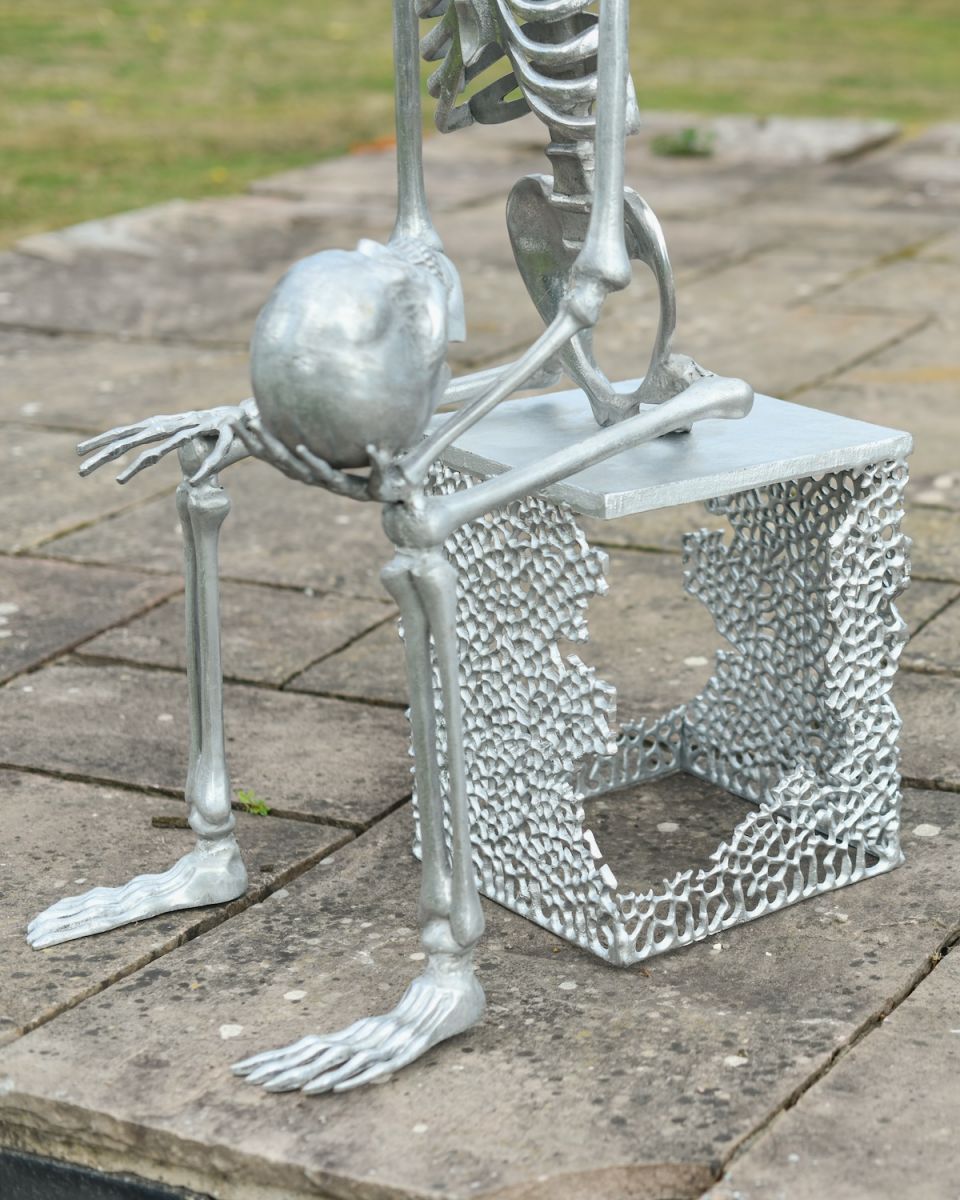 Close up of freestanding base on skulls and skeletons outdoor sculpture