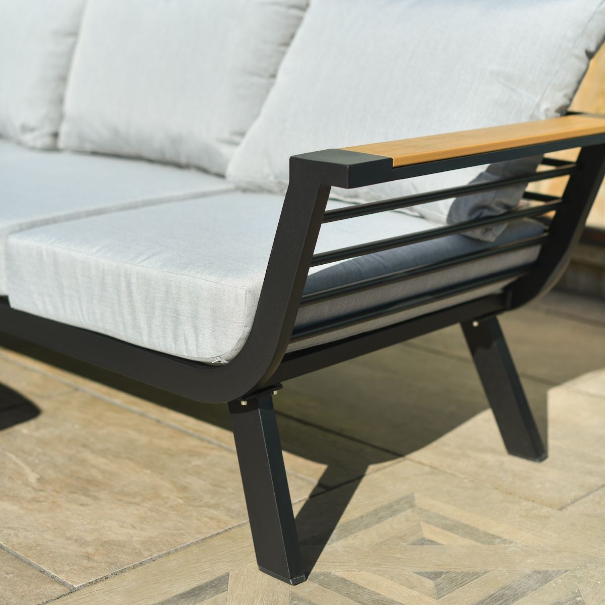 Close up of modern black metal frame on three seater sofa on garden lounge furniture set