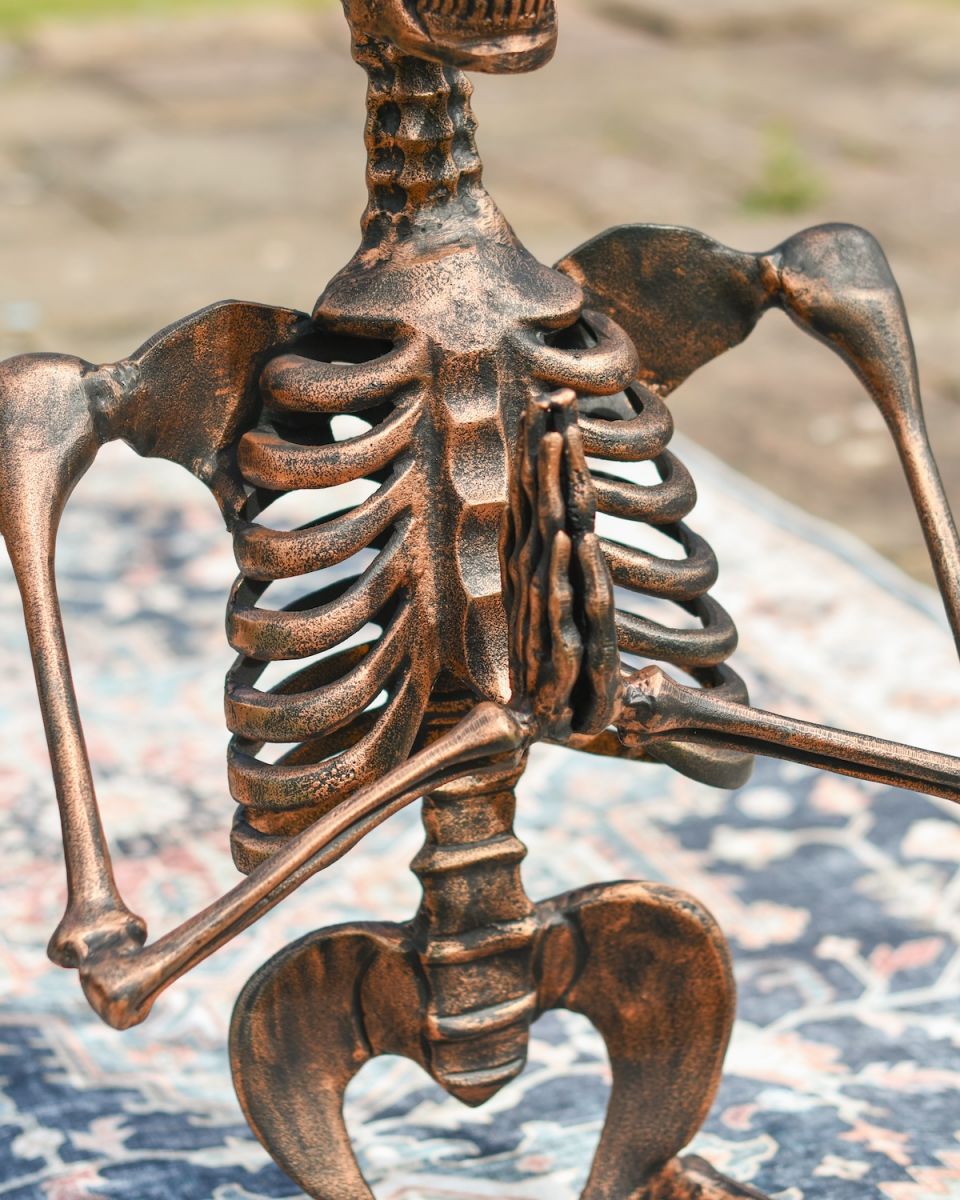 Close up of intricate rib and body detail on meditating skeleton garden sculpture