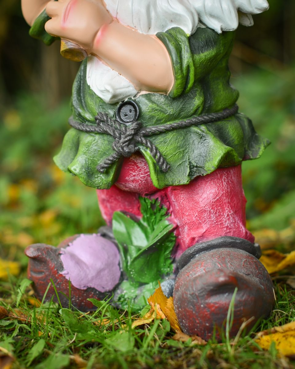 Close up of intricate clothes detail on colourful garden gnome sculpture