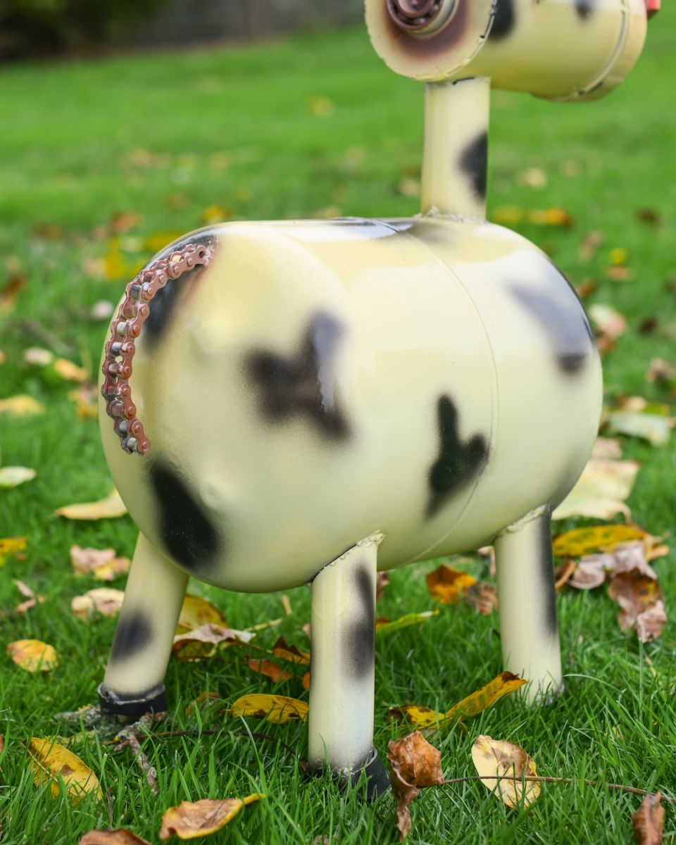 Close up of bike chain tail detail on recycled metal cow garden sculpture
