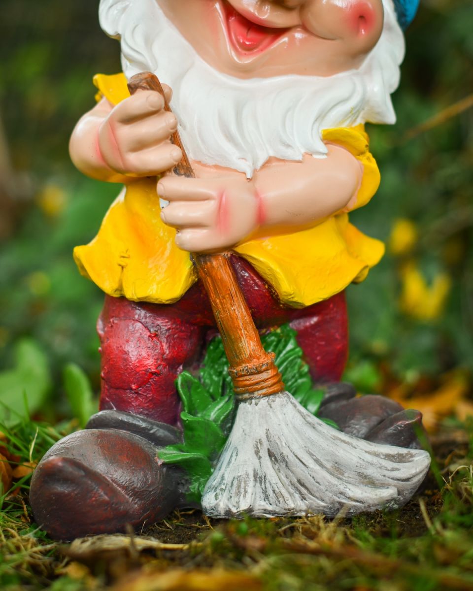 Close up of broom detail on colourful garden gnome sculpture
