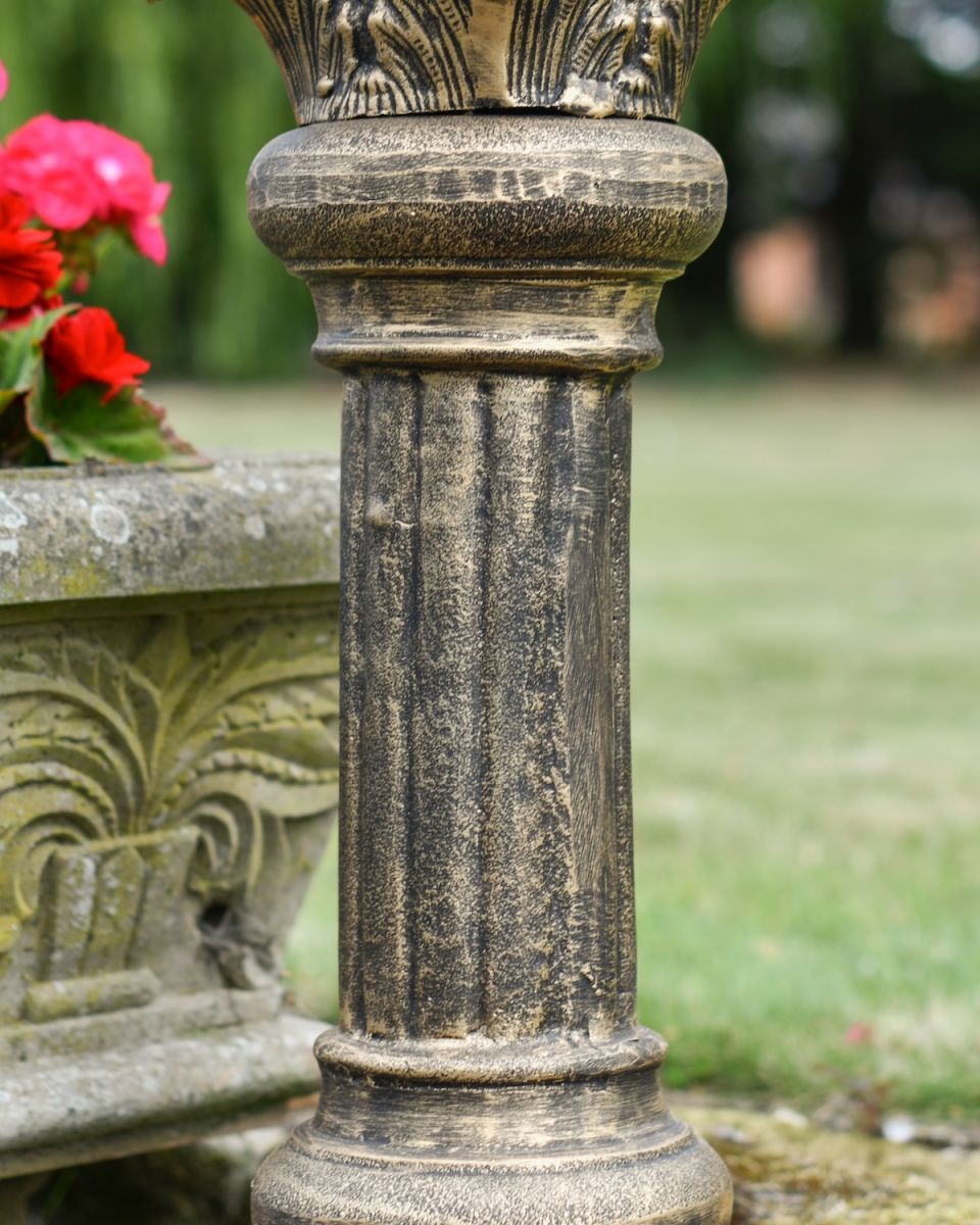 Close up of brushed gold detailing on garden sundial column