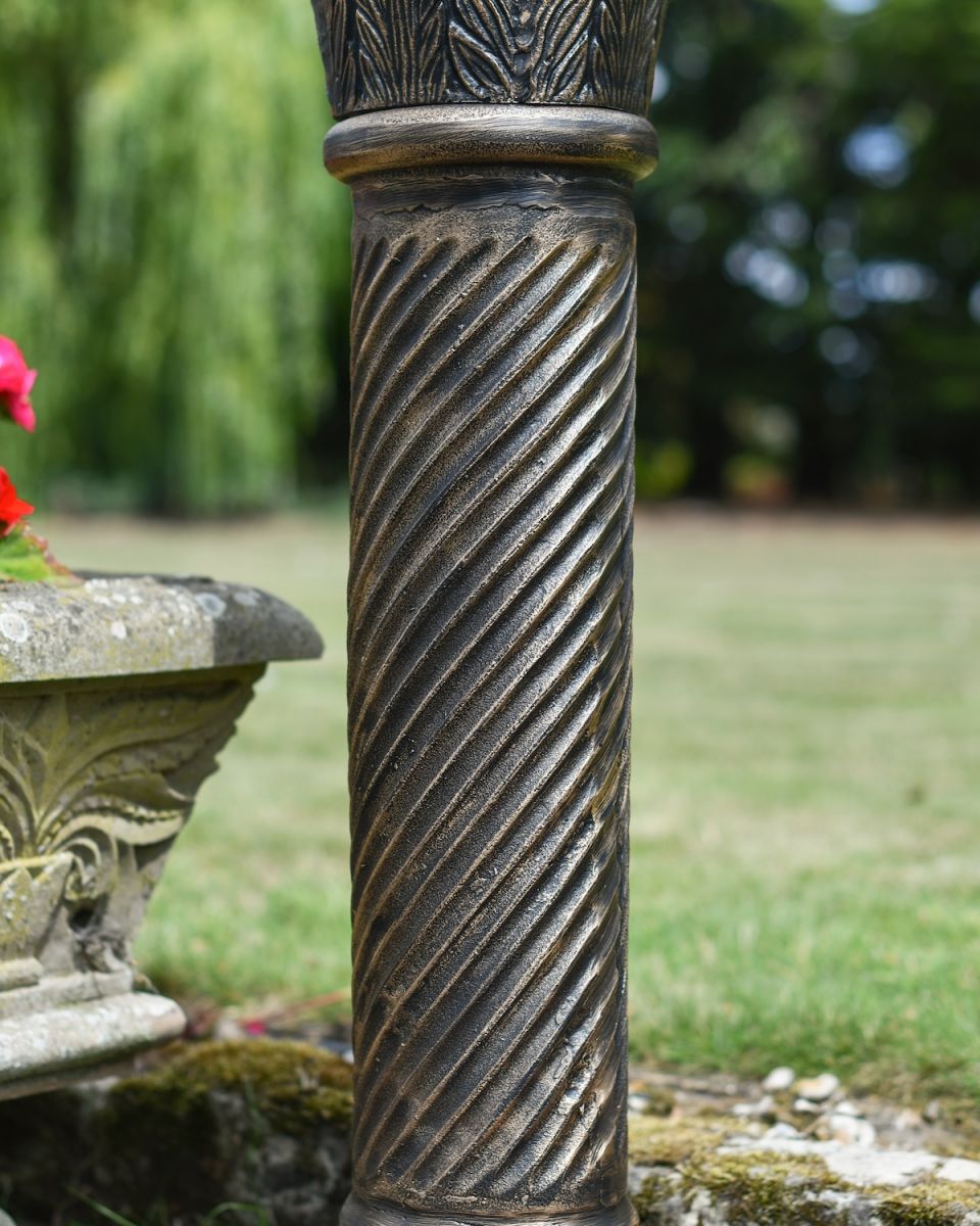 Close up of brushed gold finish on garden sundial column