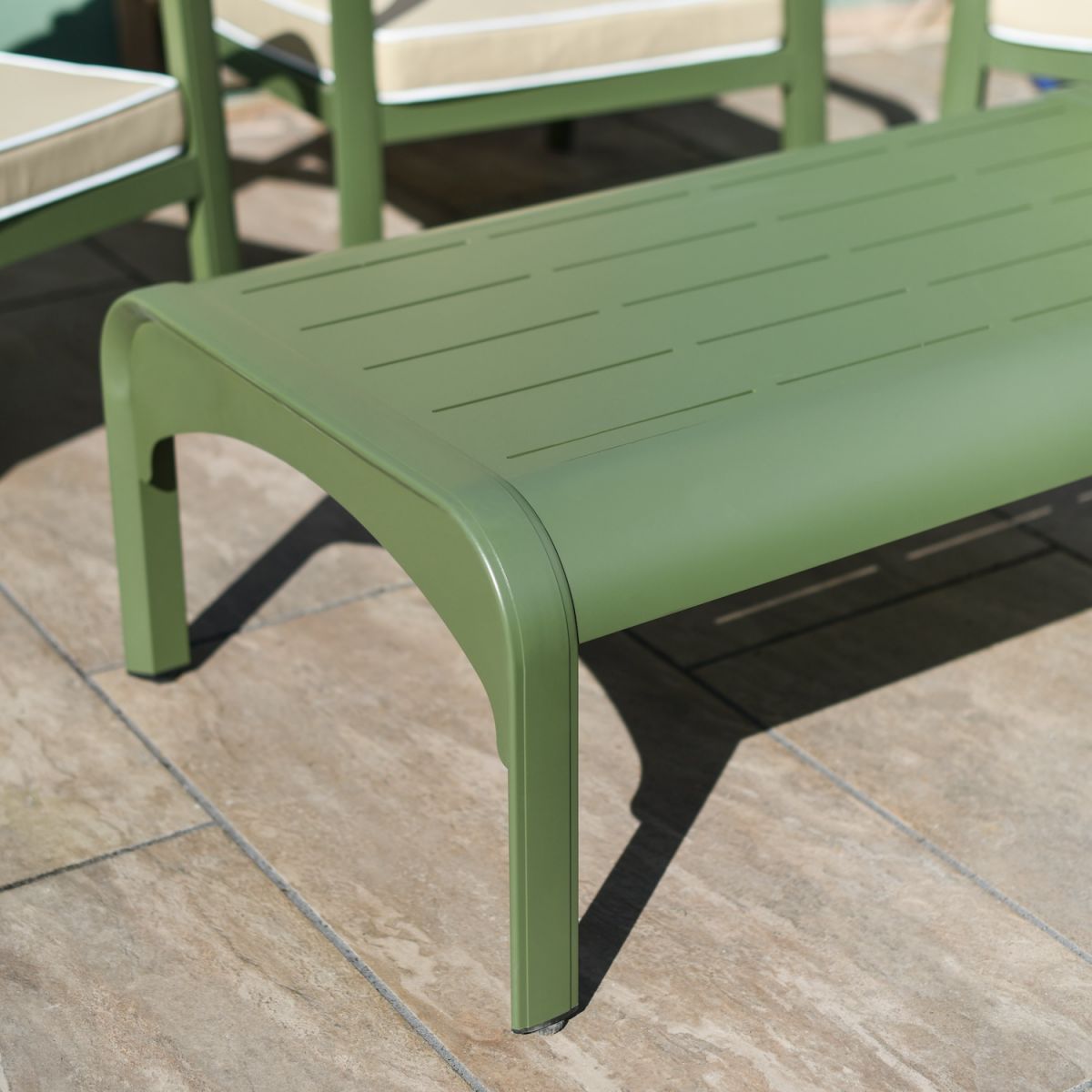 Close up of green aluminium coffee table on outdoor five person lounge set
