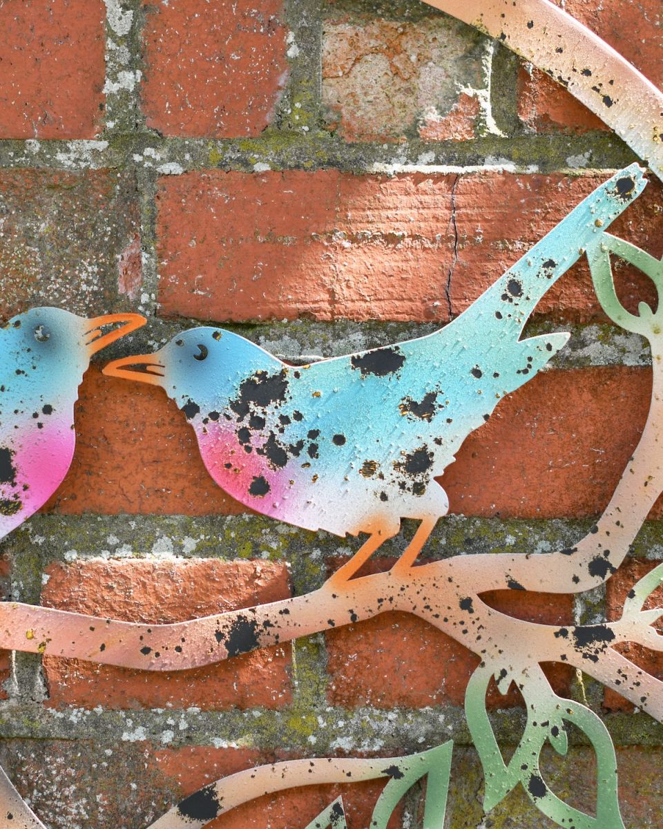 Close up of colourful bird detailing on rustic outdoor wall art Close up of colourful bird detailing on rustic outdoor wall art