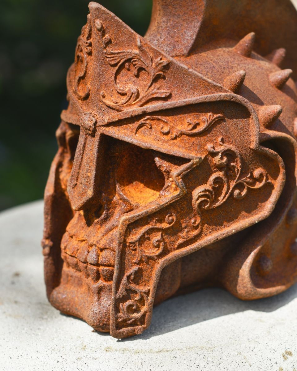 detailed close up of rusted gladiator skull garden ornament