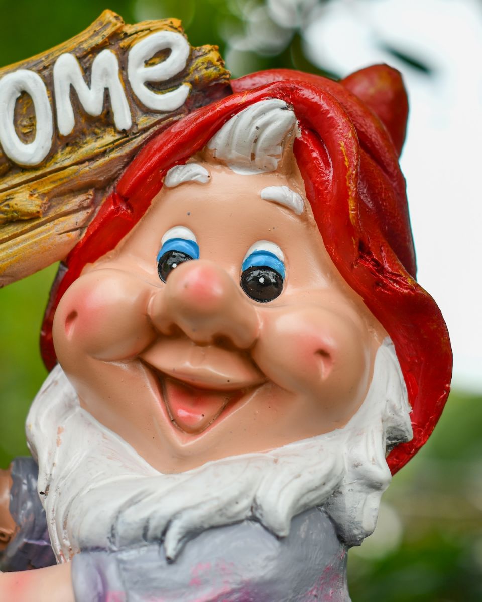 Close up of intricate face detail on colourful garden gnome sculpture