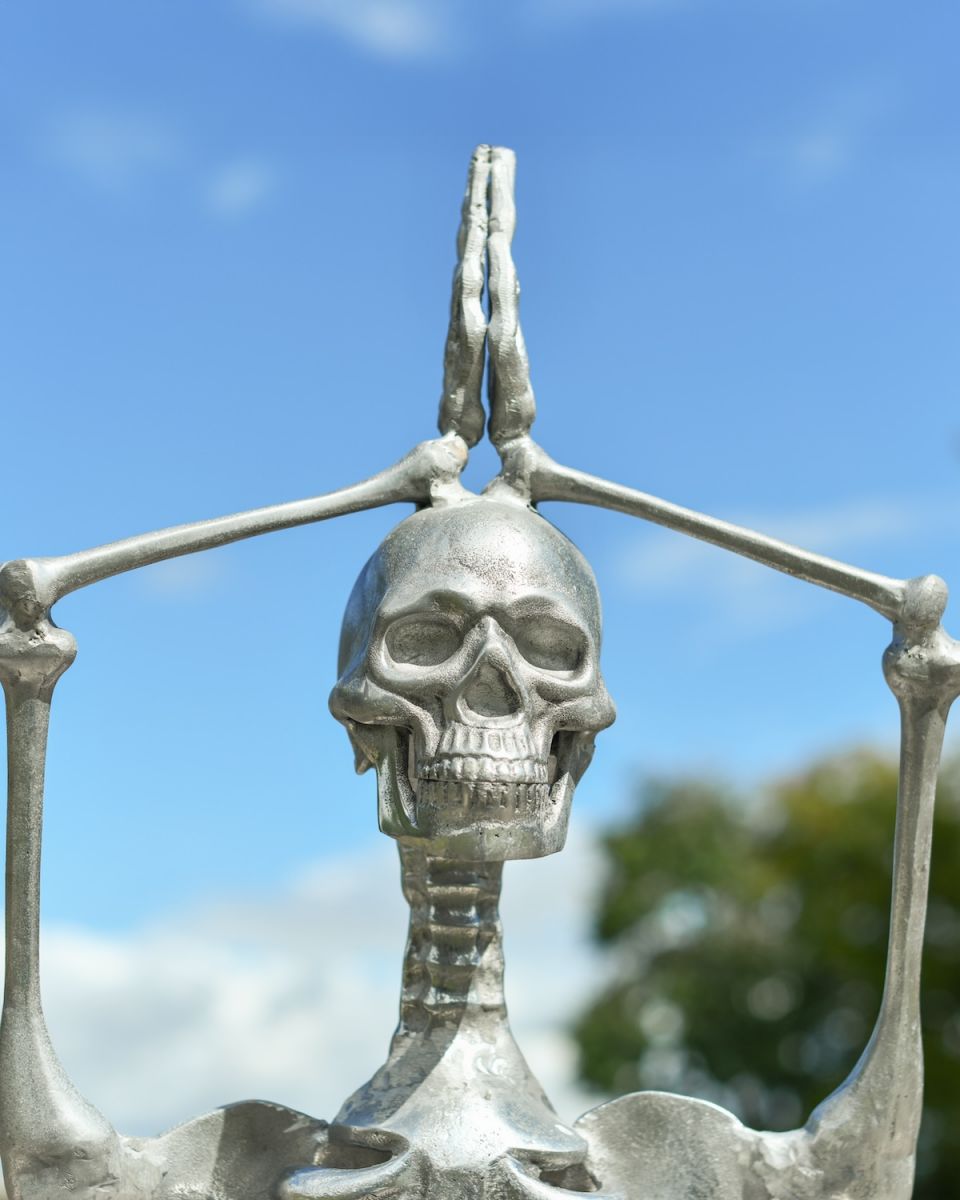 Close up of intricate face and hand detail on skeleton outdoor sculpture