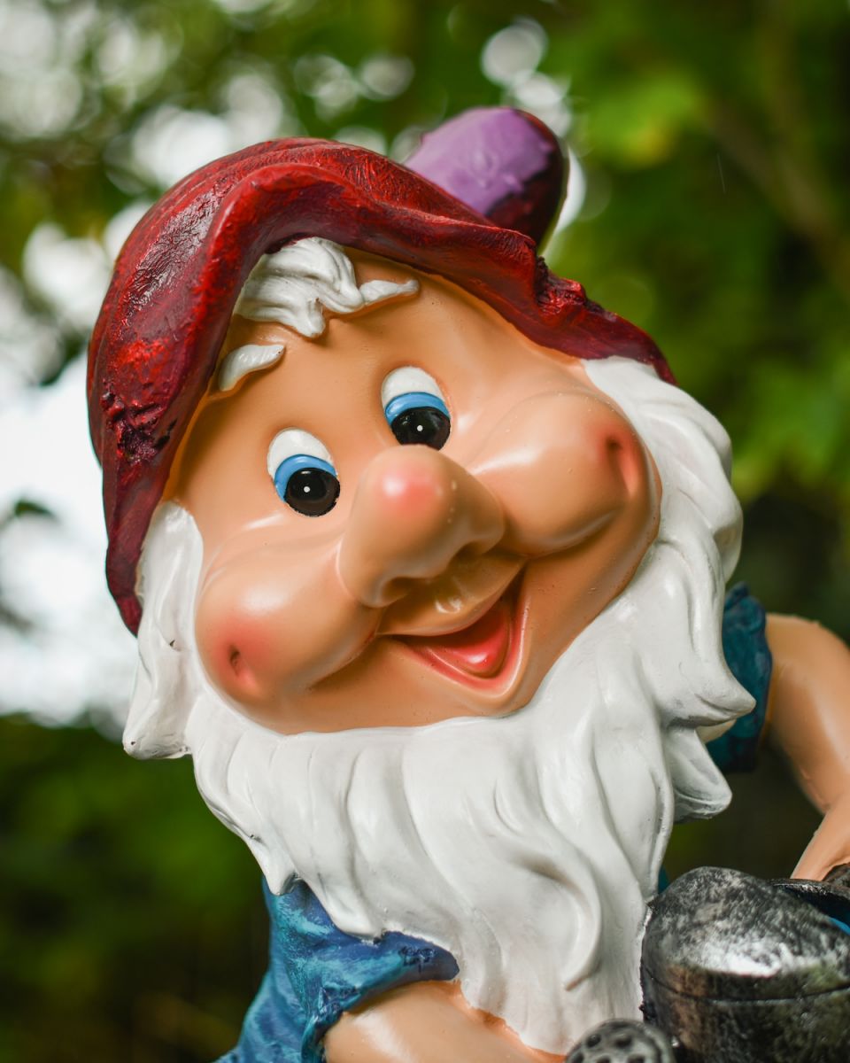 Close up of intricate face detail on colourful garden gnome ornament