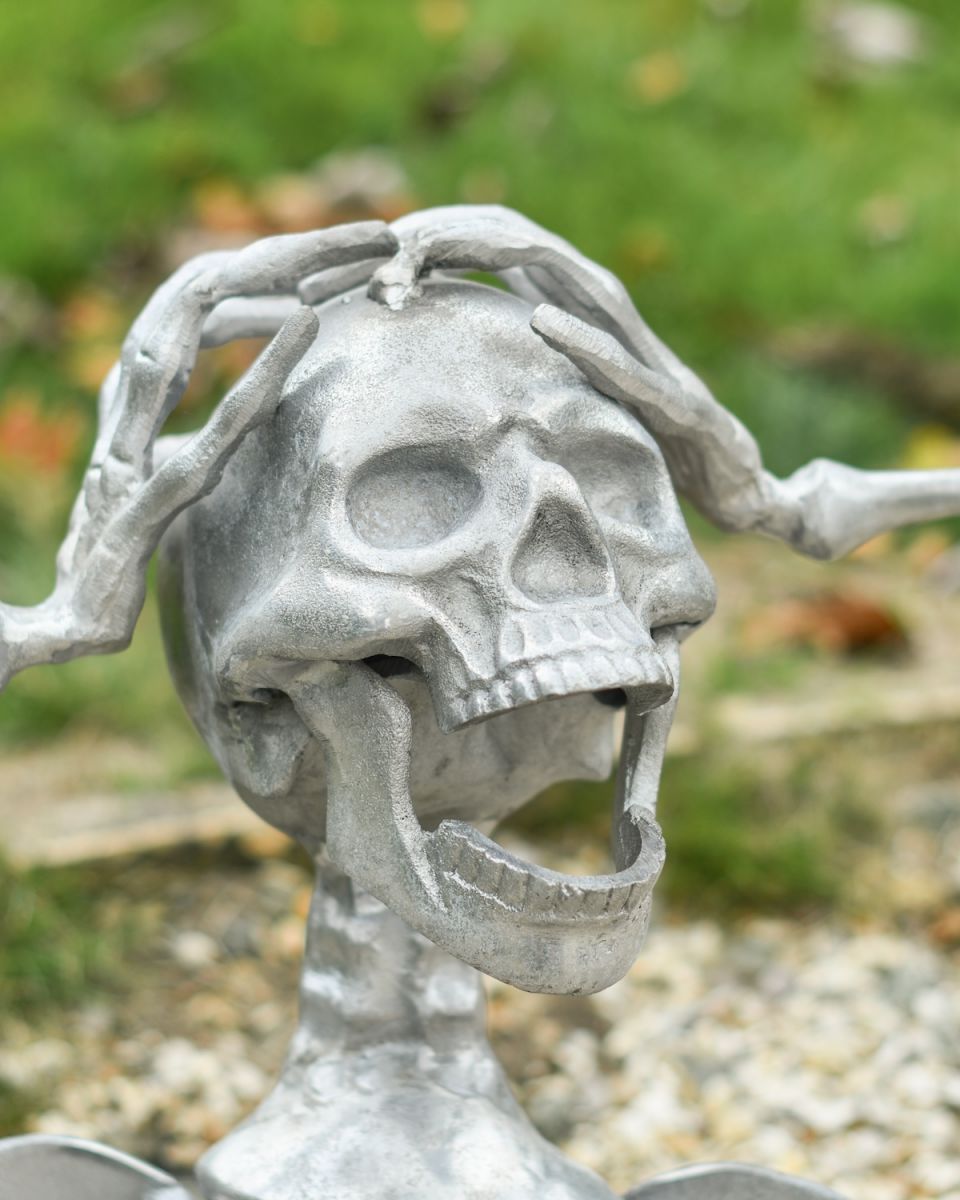 Close up of face detail on half skeleton garden sculpture