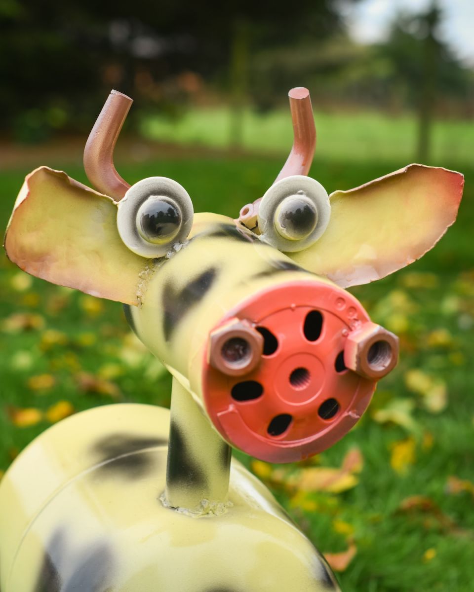 Close up of intricate face detail on recycled metal cow outdoor sculpture