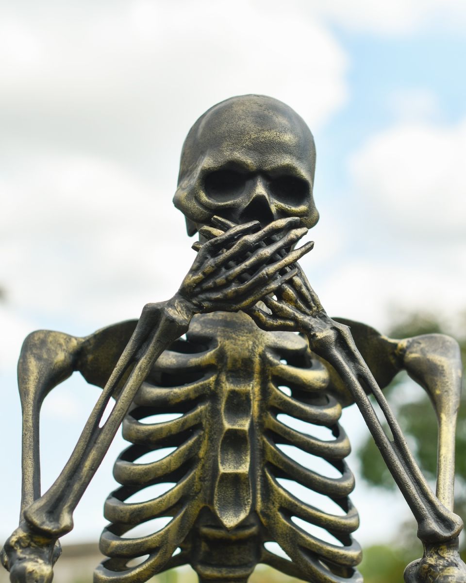 Close up of intricate hand and face detail on skeleton garden sculpture