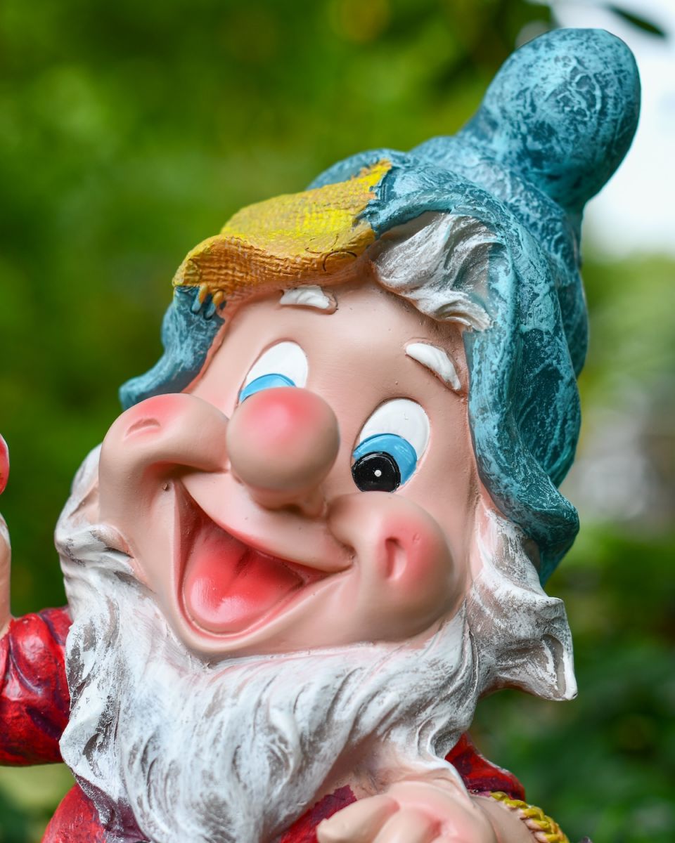 Angled close up of intricate face detail on colourful garden gnome statue