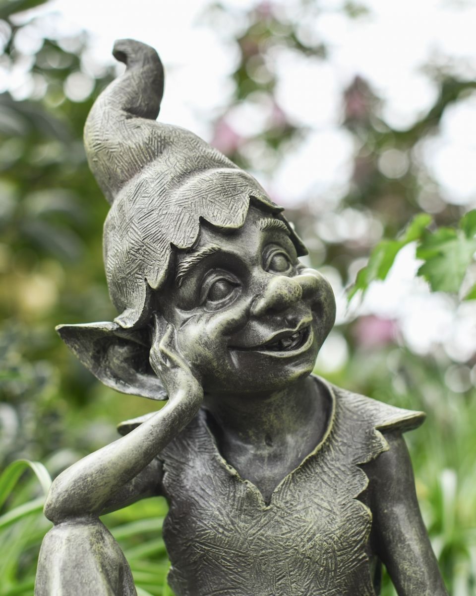 close up of intricate face and hat detail on patio ornament