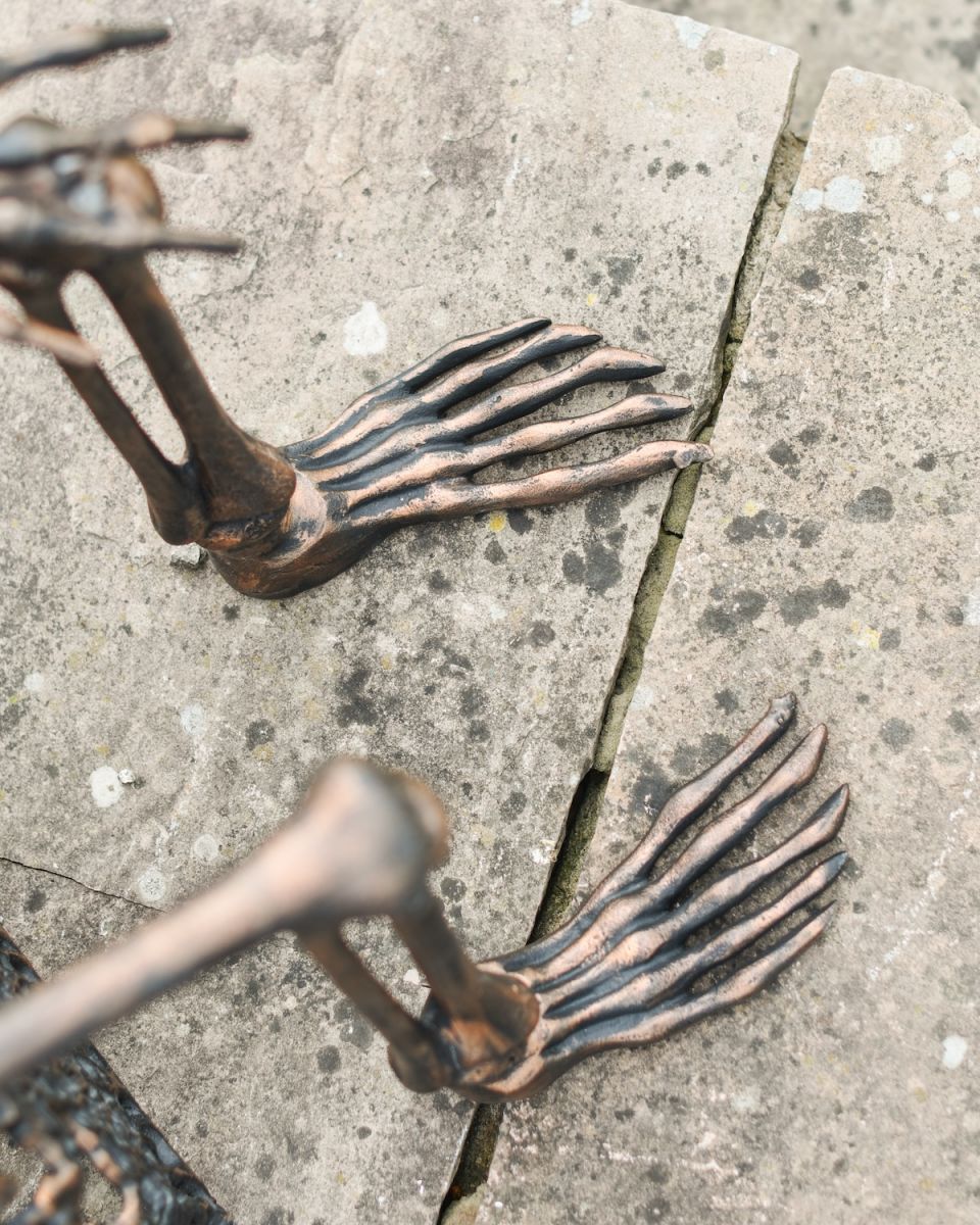 Close up of intricate feet detail on aluminium skeleton garden sculpture