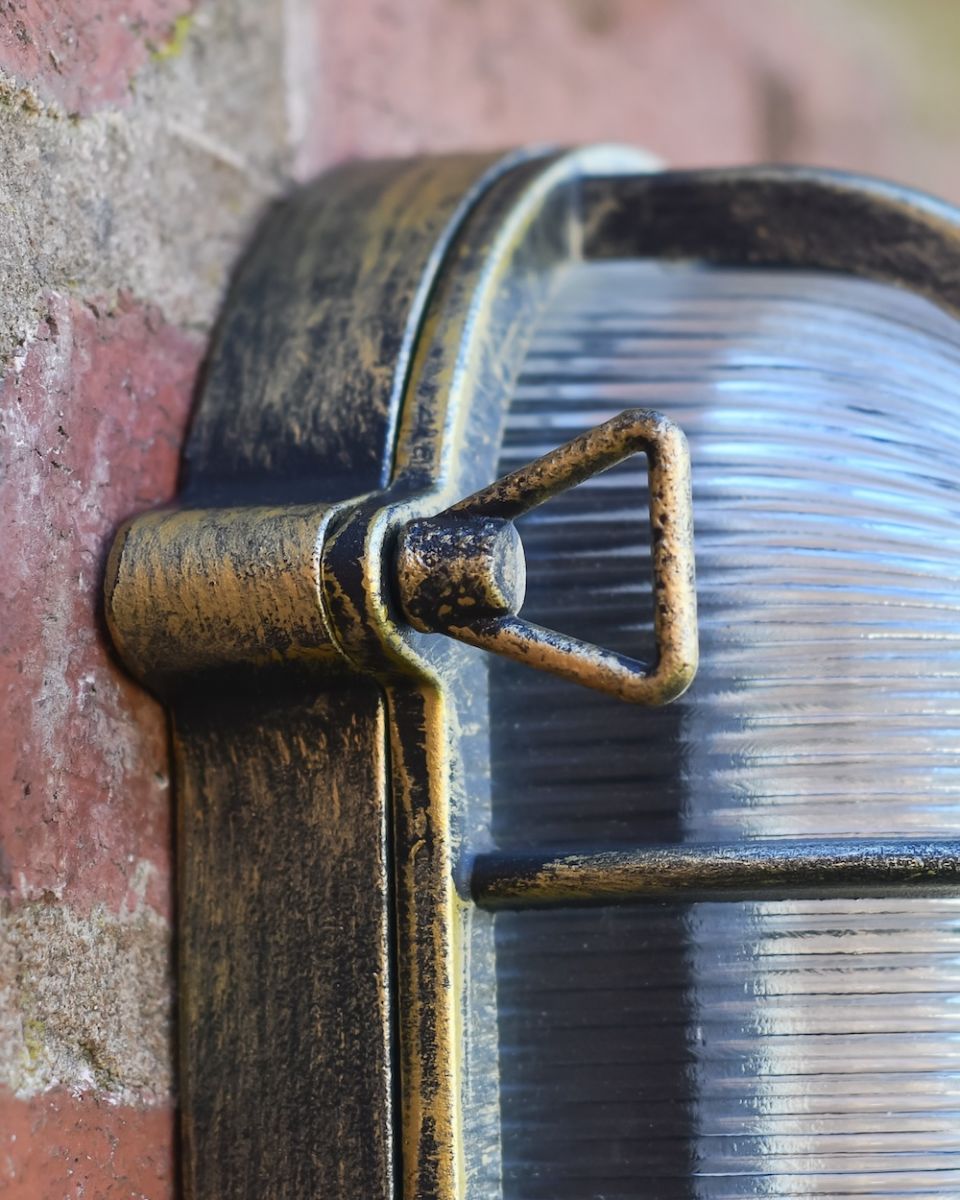 Close up of antique brushed brass fixture detail on garden wall light