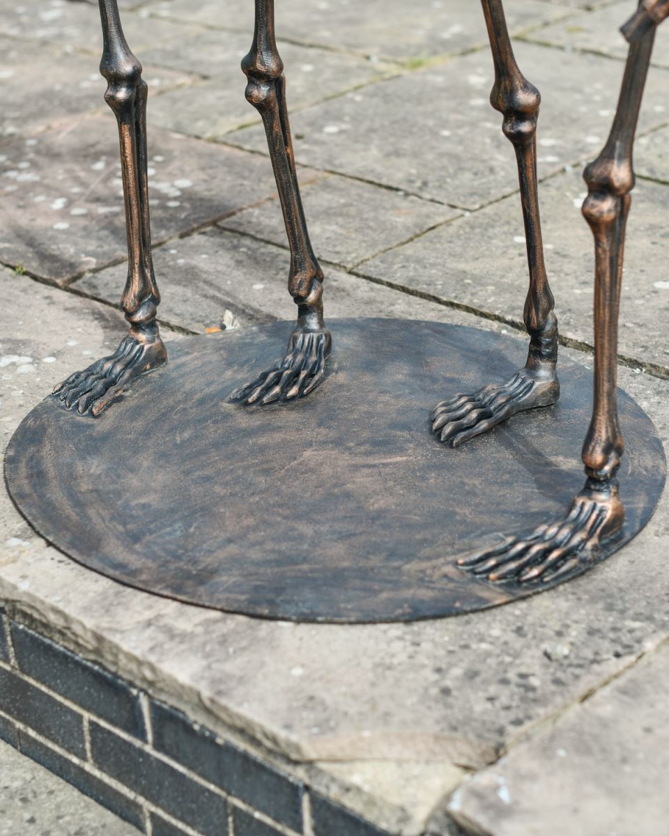 Close up of feet detail and freestanding base on outdoor skeleton statue