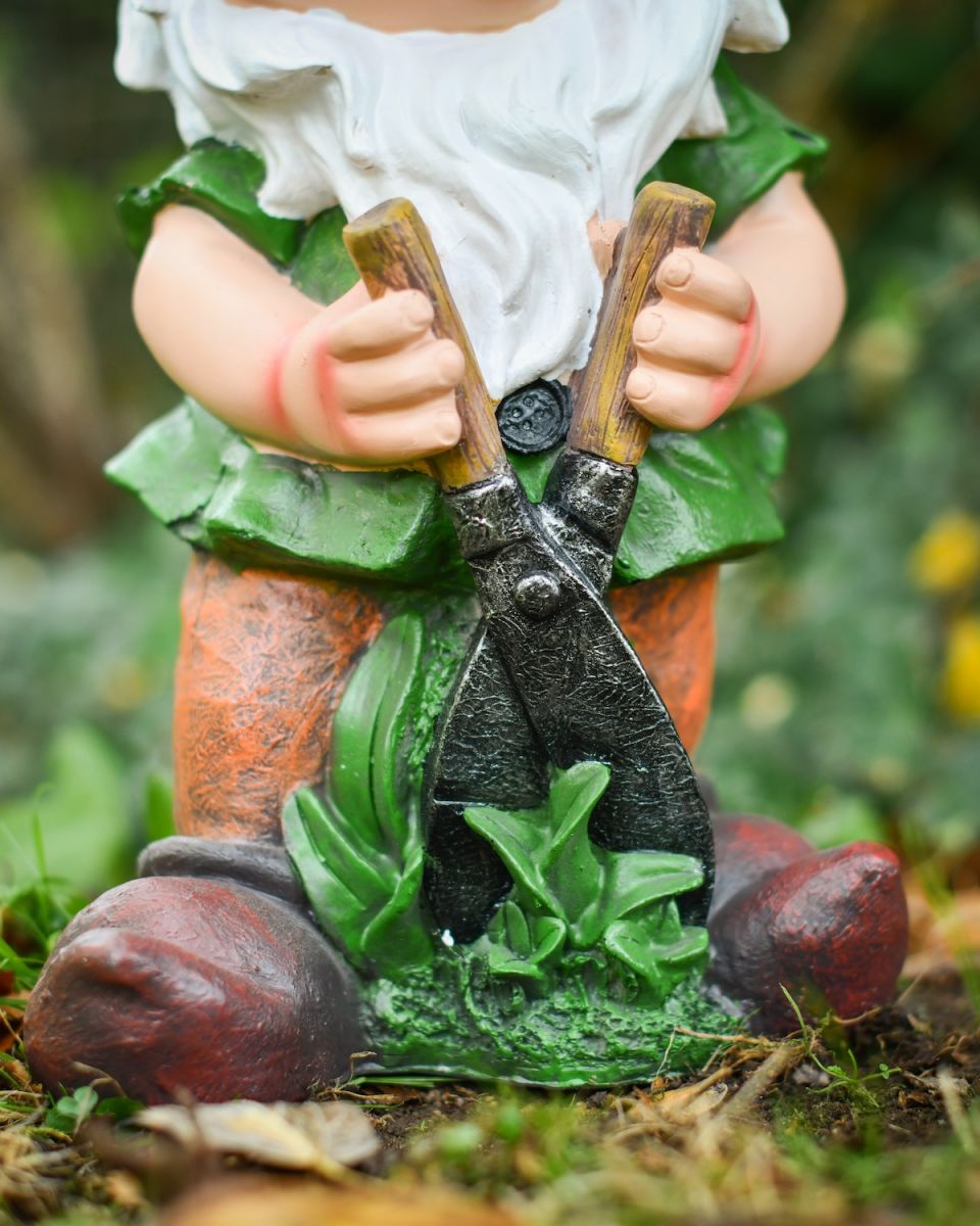 Close up of gardening shears detail on colourful garden gnome
