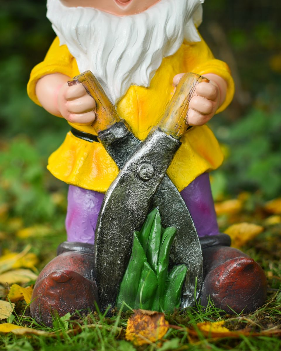Close up of gardening shears detail on colourful outdoor gnome sculpture Close up of gardening shears detail on colourful outdoor gnome sculpture