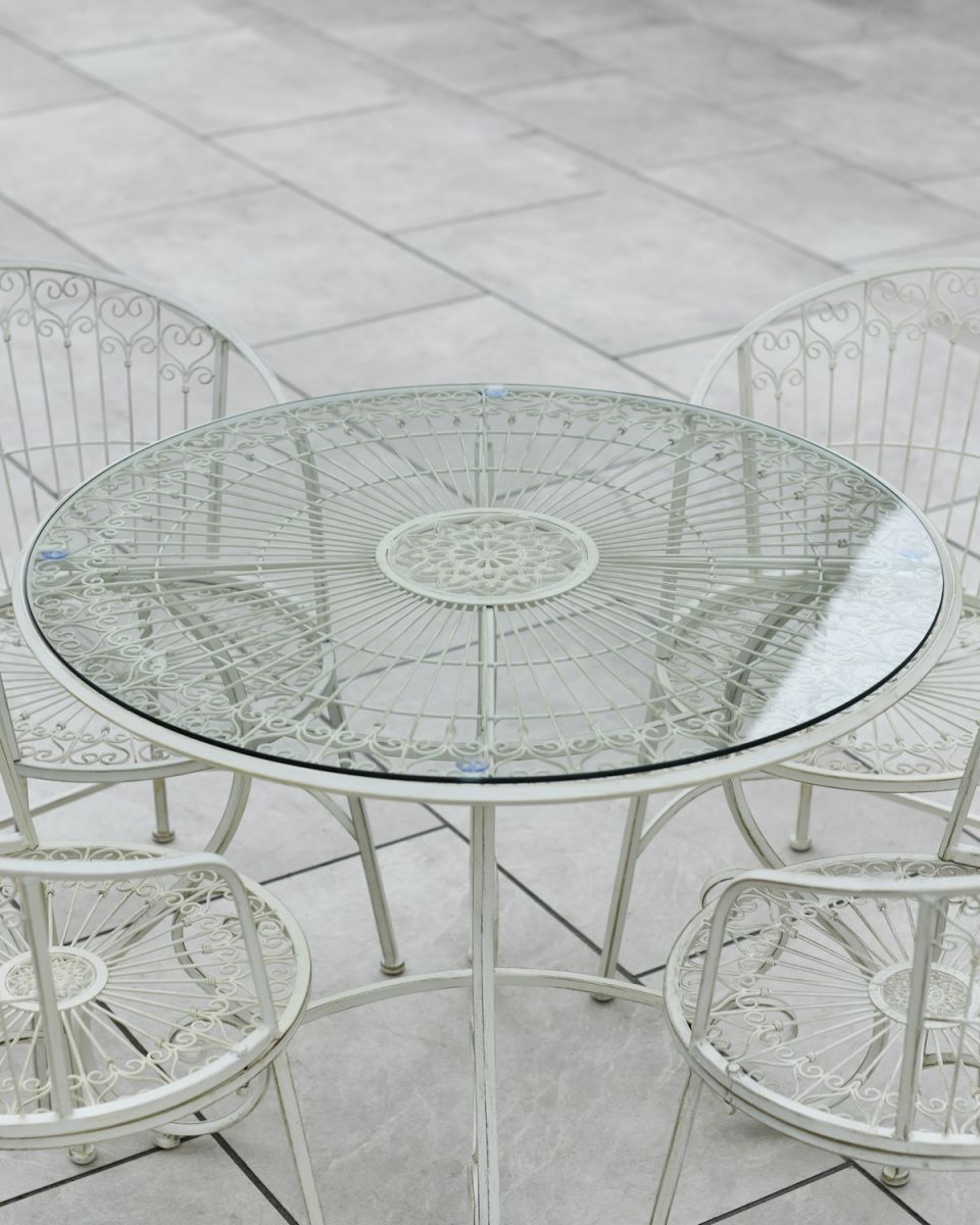 Close up of glass table top detail on four seater outdoor table and chairs set Close up of glass table top detail on four seater outdoor table and chairs set