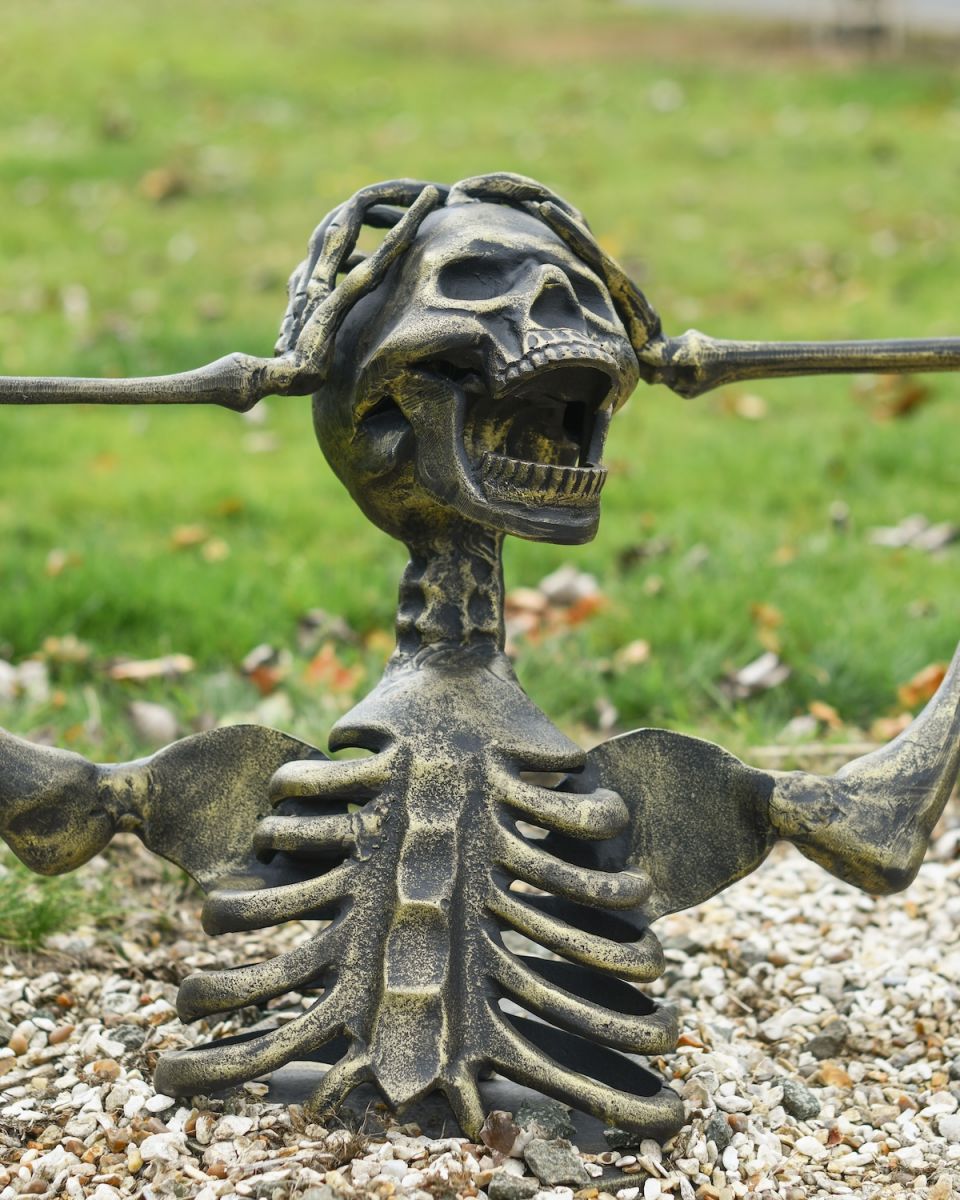 Close up of screaming half skeleton on outdoor statue