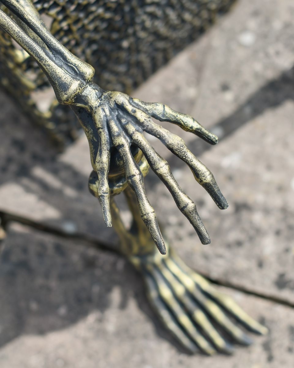 Close up of intricate skeleton hand on garden sculpture