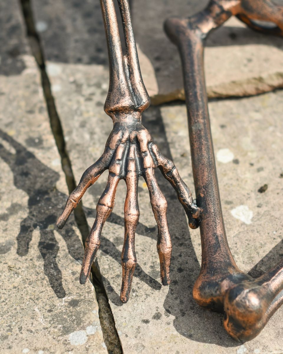 Close up of intricate skeleton hand detail on garden statue