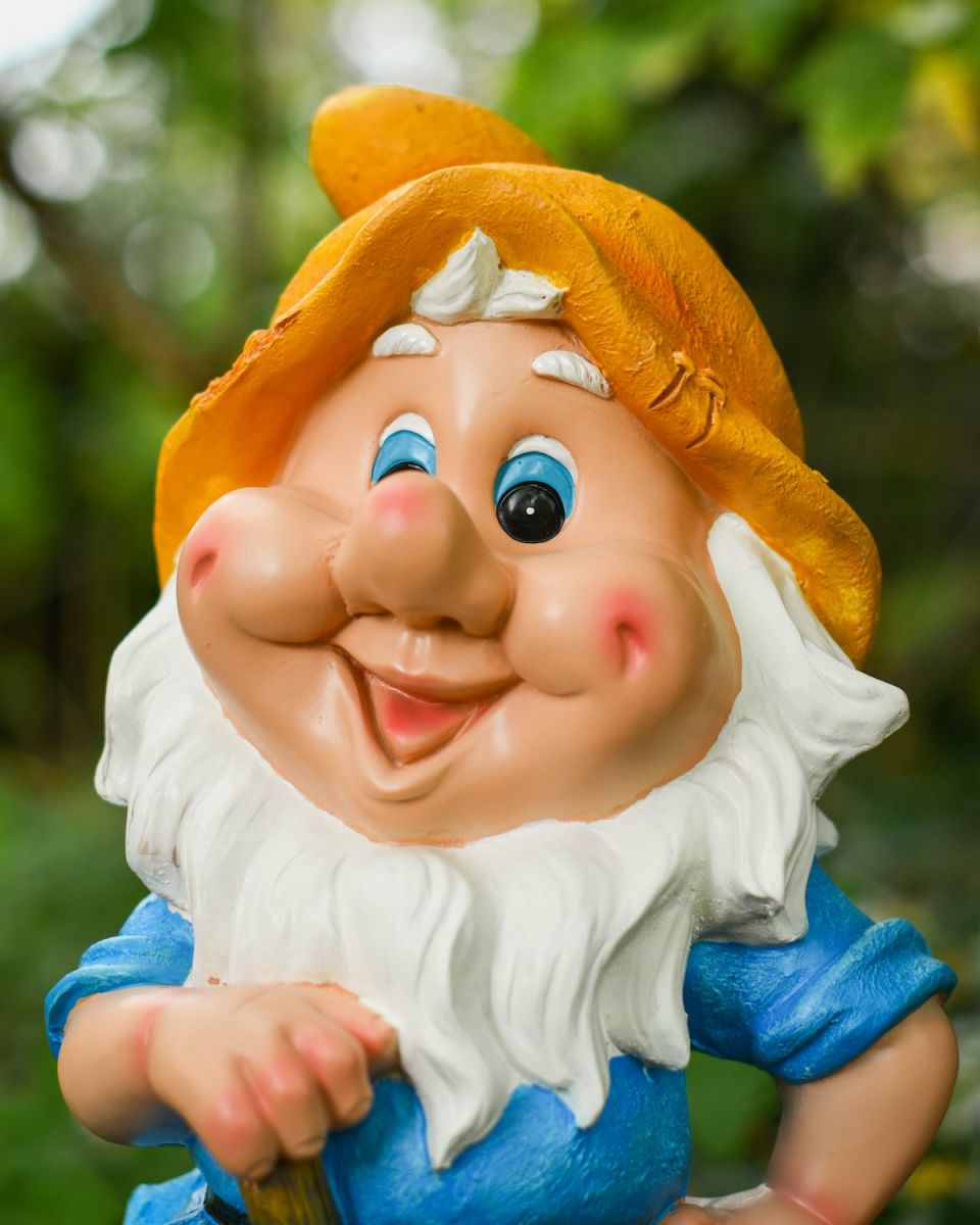 Close up of intricate face detail on colourful garden gnome sculpture