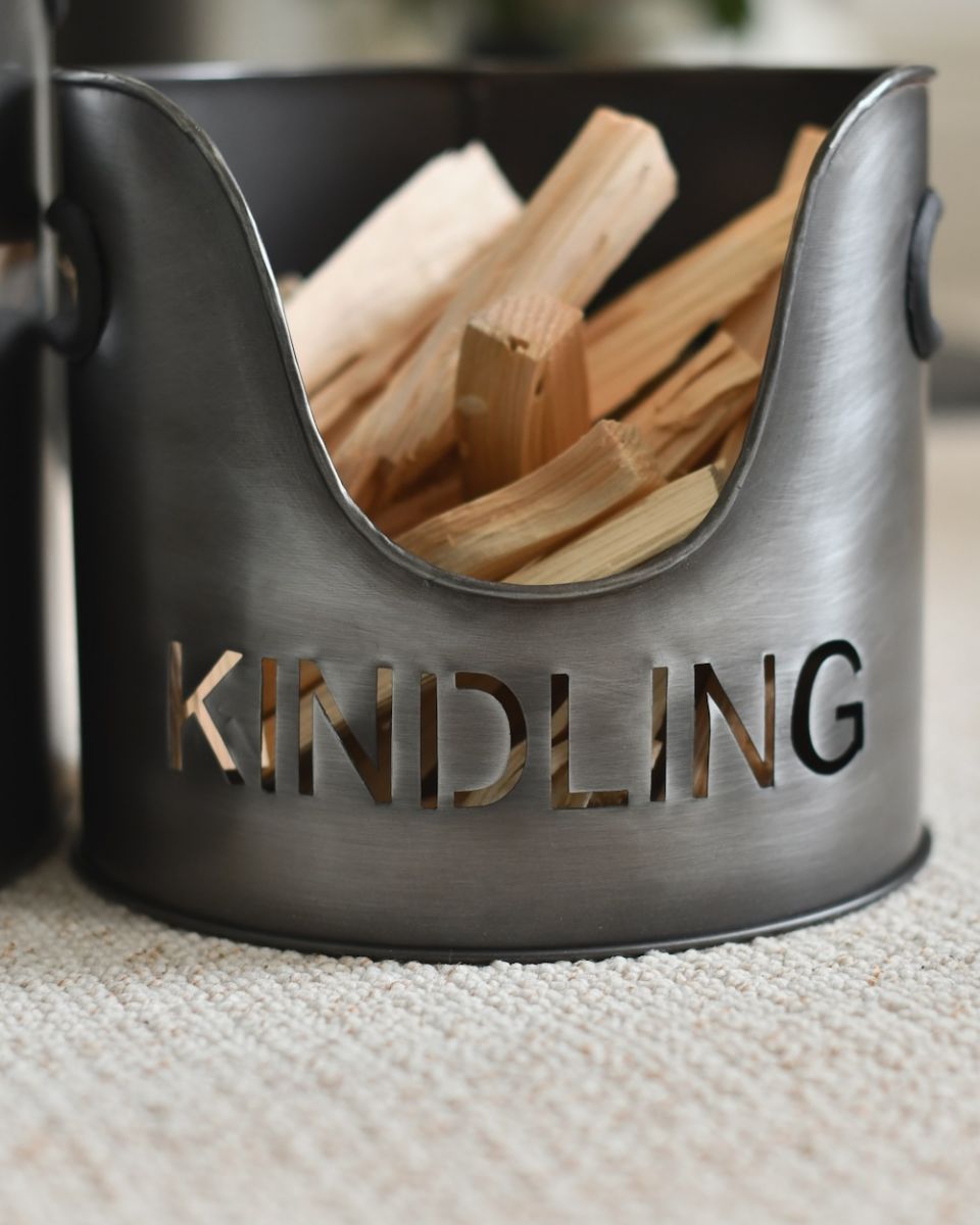 close up of cut out writing of kindling silver fire bucket close up of cut out writing of kindling silver fire bucket