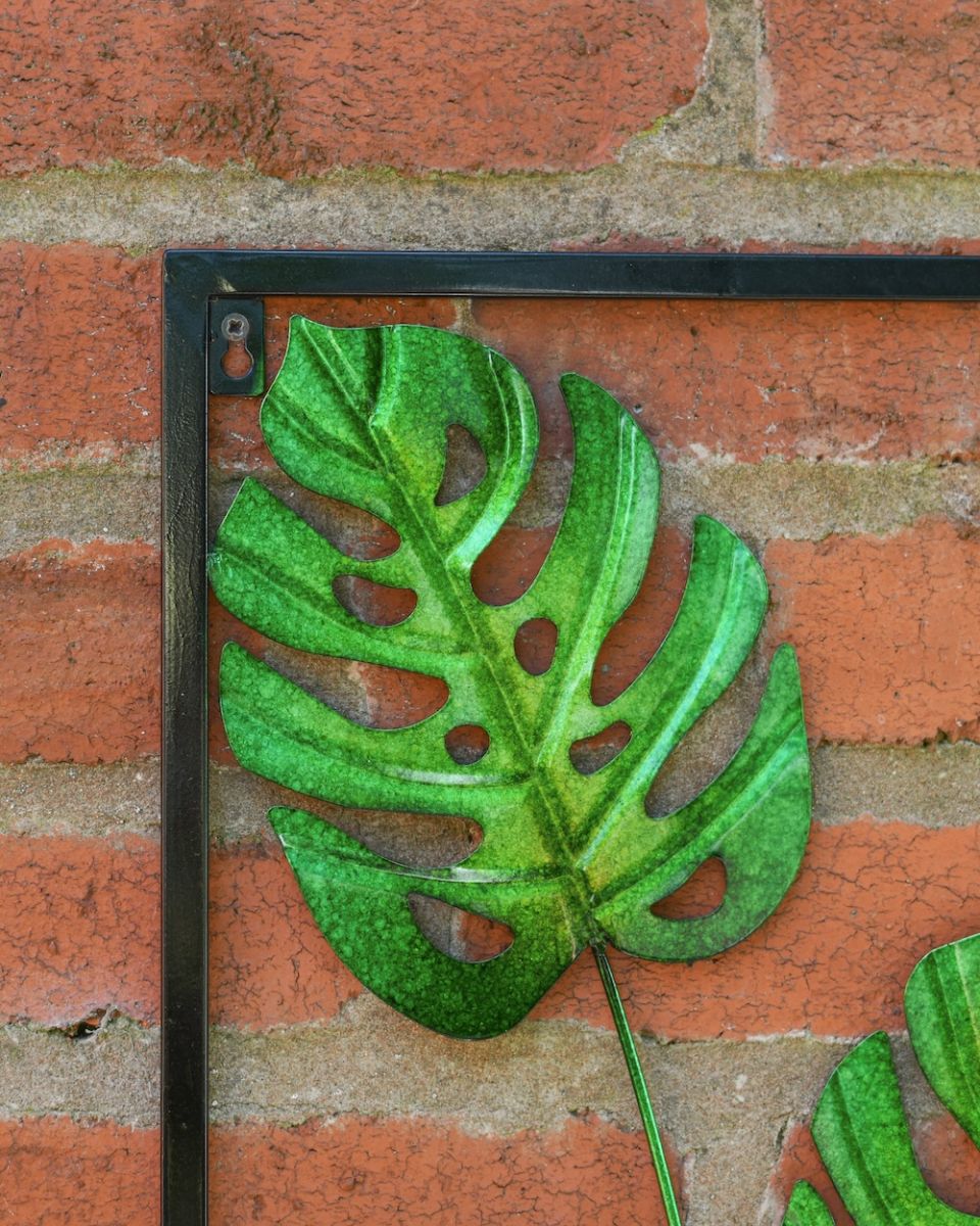 Close up of black border and green monstera leaf wall art