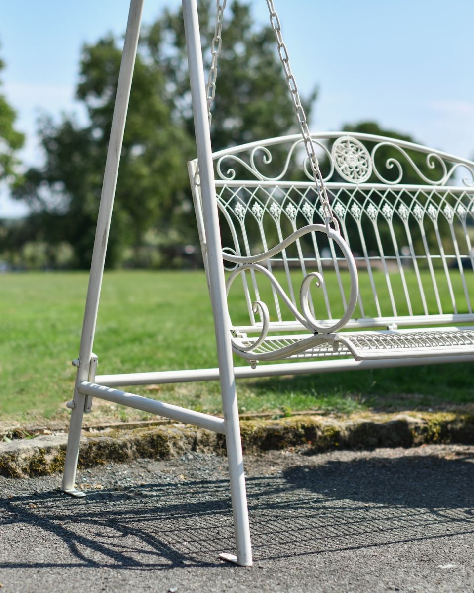 Close up of ornate scrollwork on garden two seater swing bench