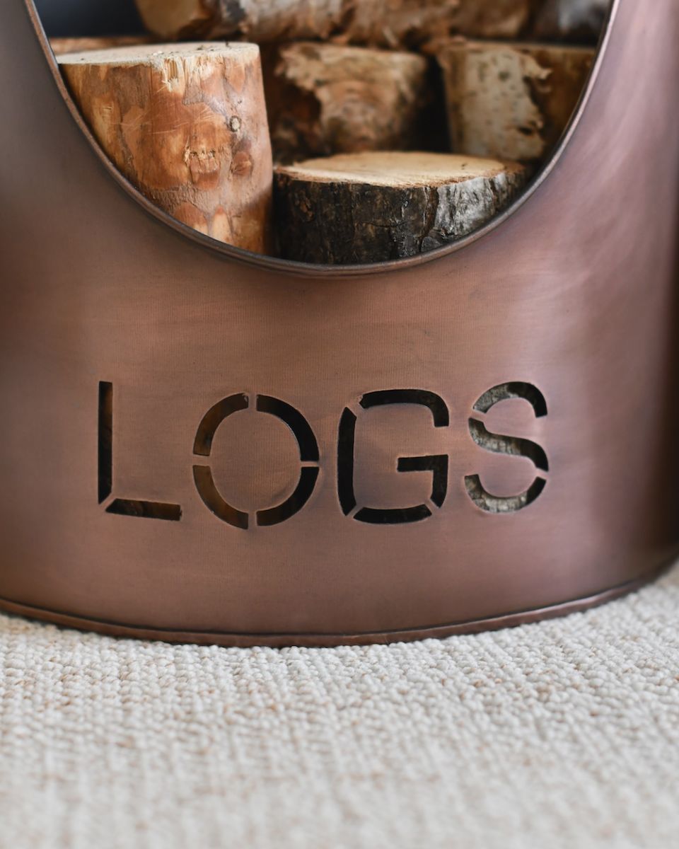 close up of cut out writing on copper log bucket
