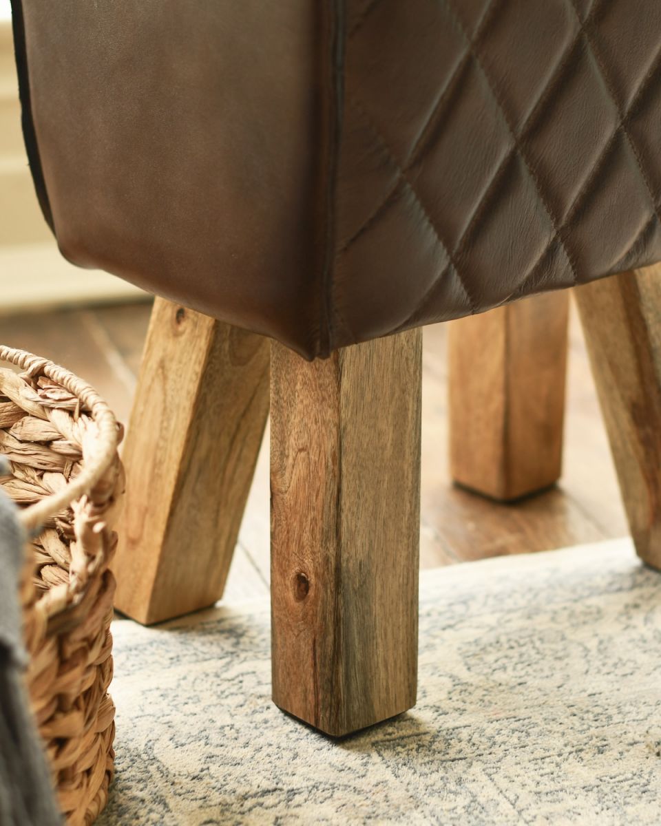 Close up of mango wood legs on leather foot stool