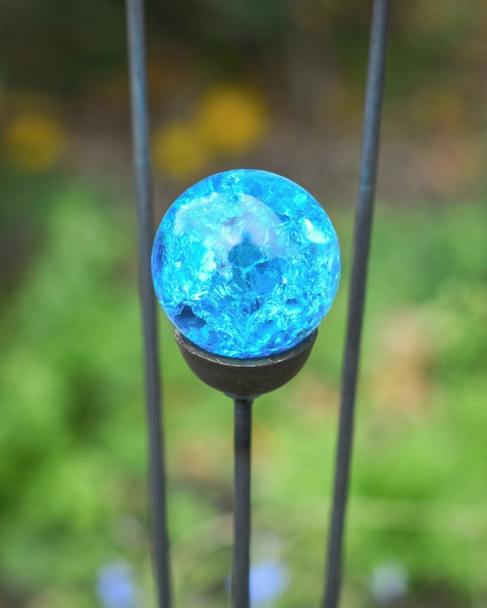 Close up of vibrant blue marble on garden suncatcher 