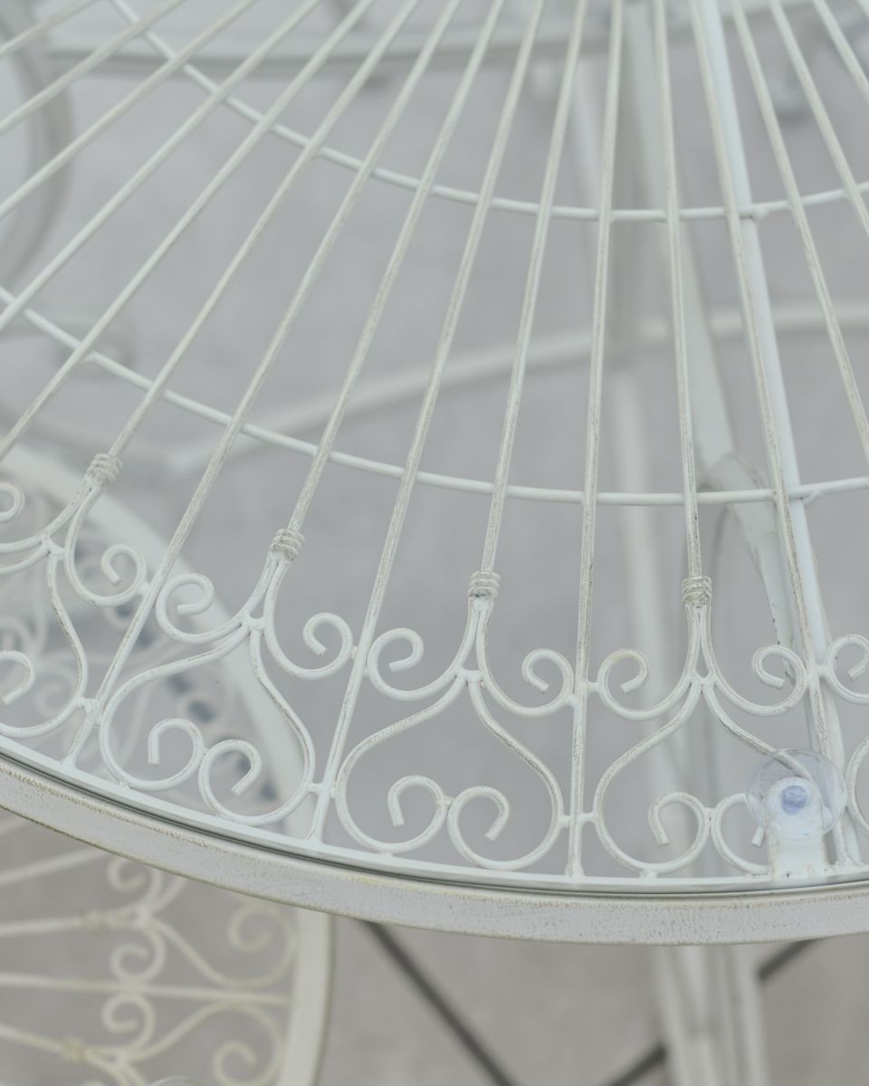 Close up of ornate detail on rustic finish white four seater outdoor dining set Close up of ornate detail on rustic finish white four seater outdoor dining set