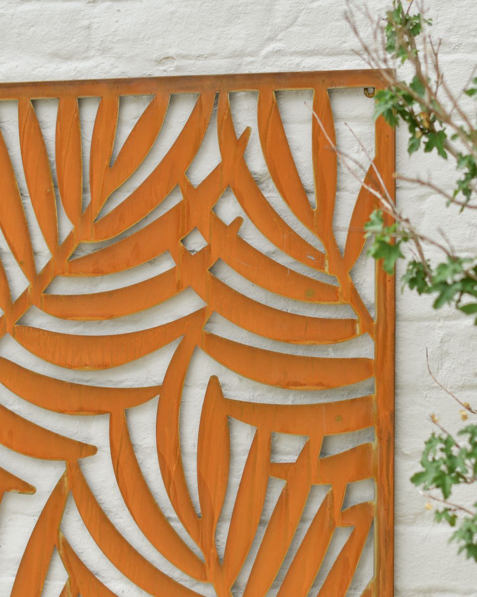 Close up of intricate palm leaf detail on rustic garden wall art