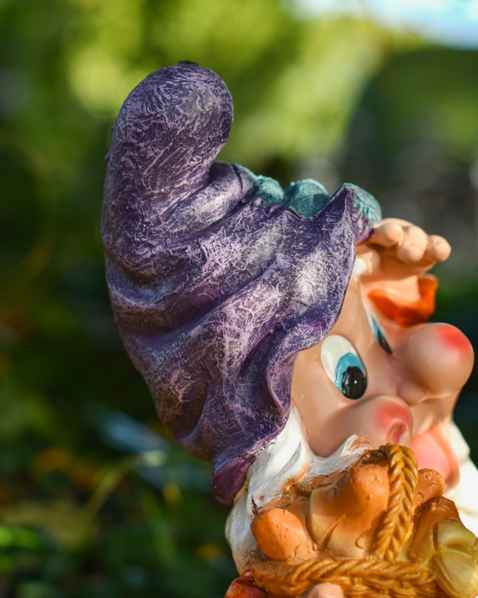 Close up of intricate detail on hat on colourful outdoor gnome statue