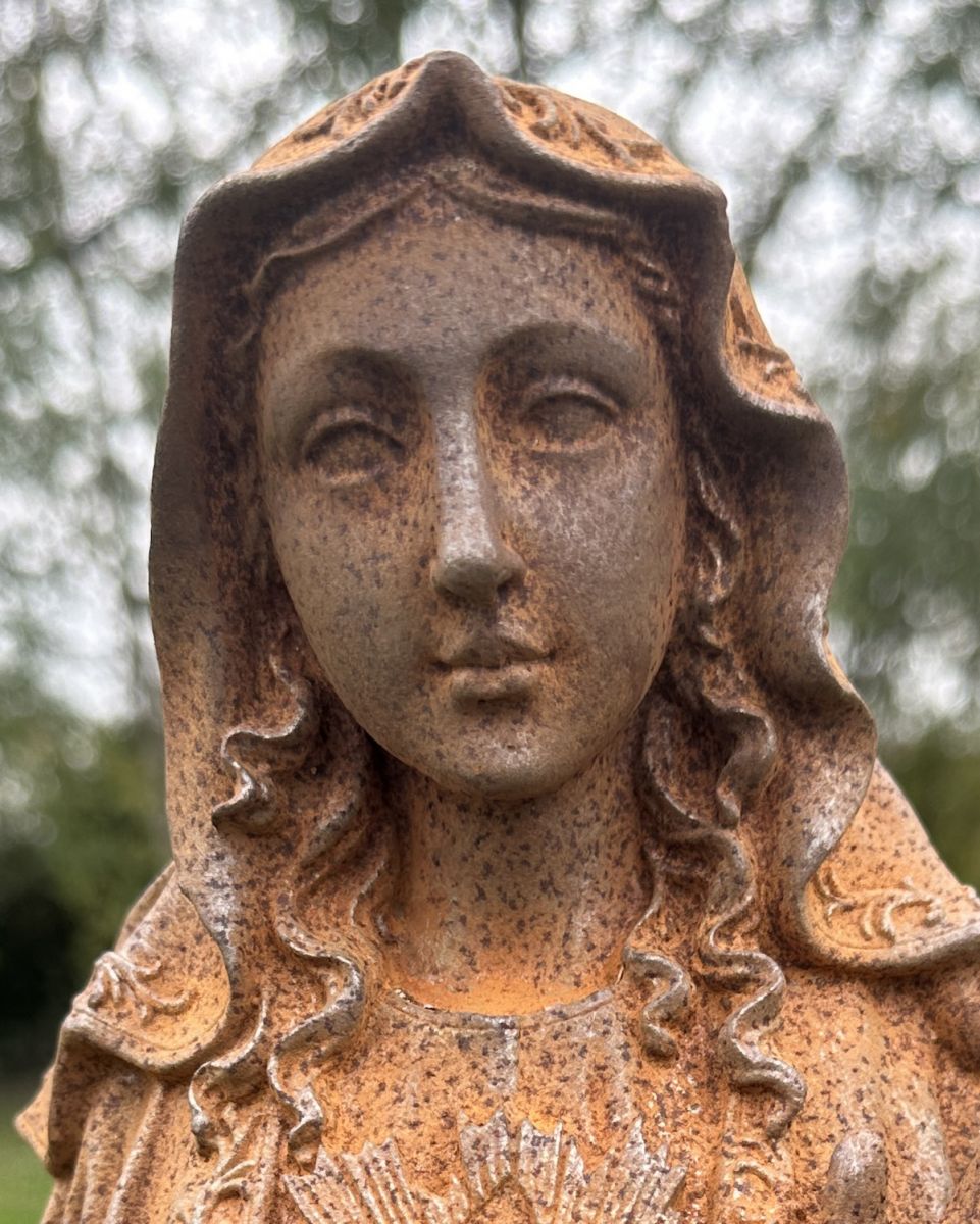 Close up of intricate face detail on rustic cast iron garden sculpture Close up of intricate face detail on rustic cast iron garden sculpture