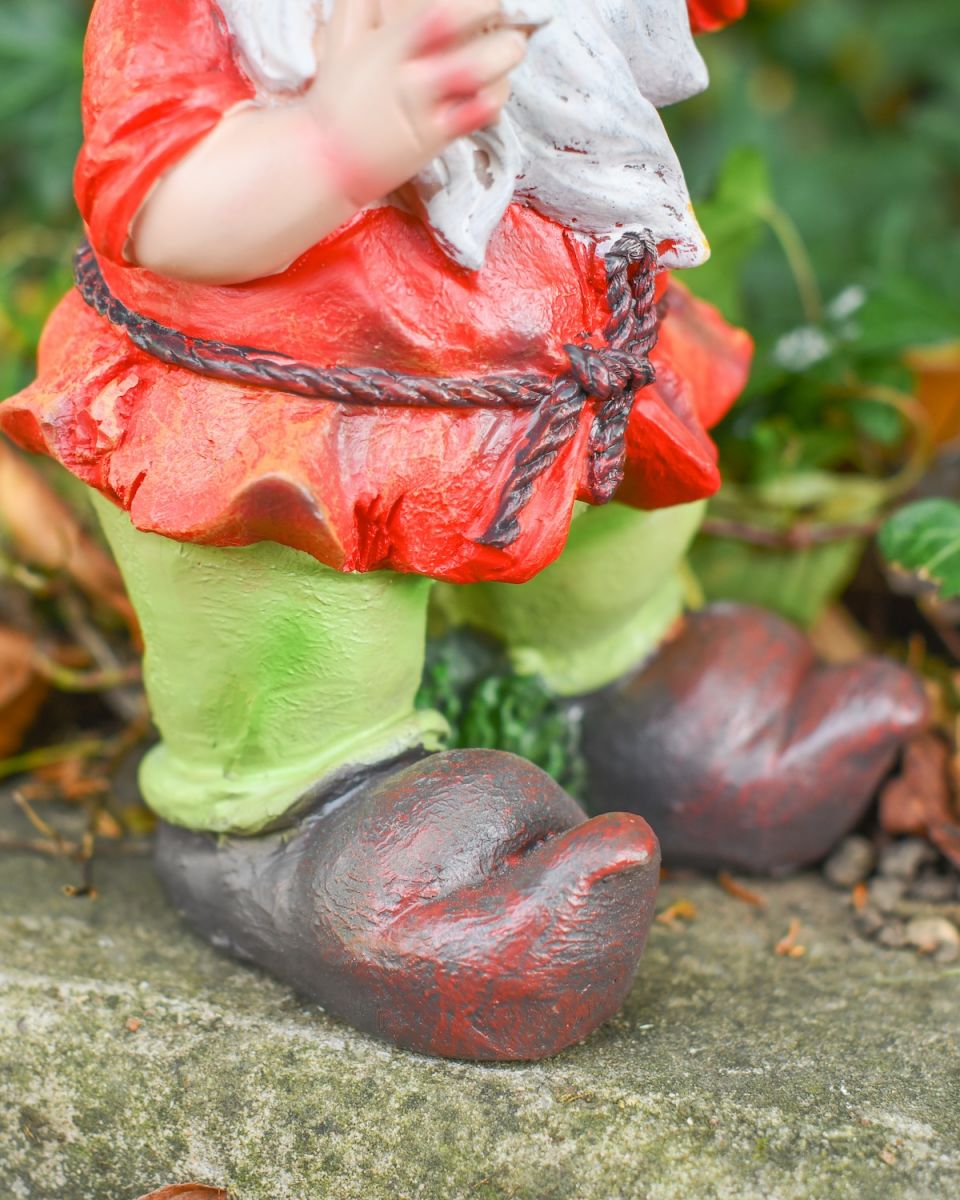 Close up of intricate shoe detail on colourful garden gnome statue