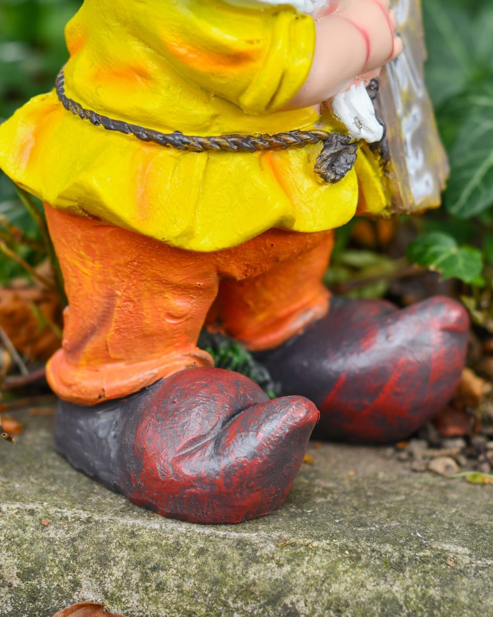 Close up of intricate shoes and clothes detail on intricate garden gnome statue