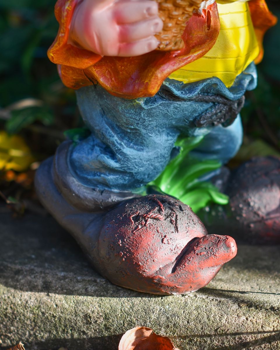 Close up of intricate clothes and shoe detail on colourful garden gnome statue