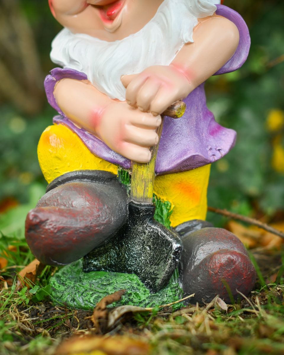 Close up of shovel digging detail on colourful outdoor gnome sculpture